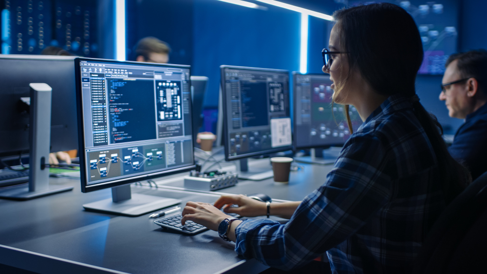 image of lady wearing glasses coding on a computer