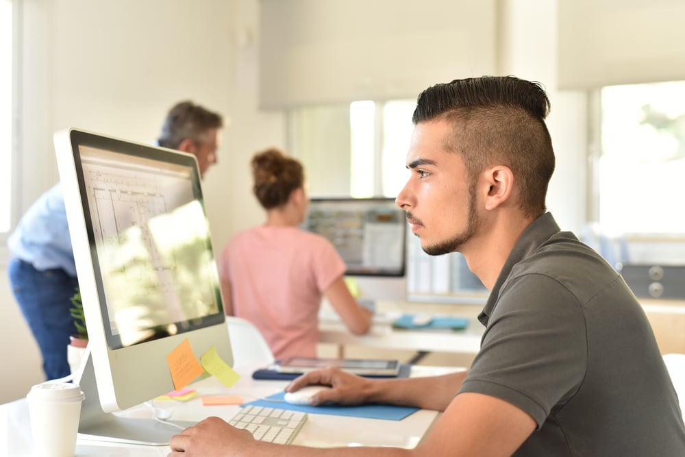 young man with beard working at computer